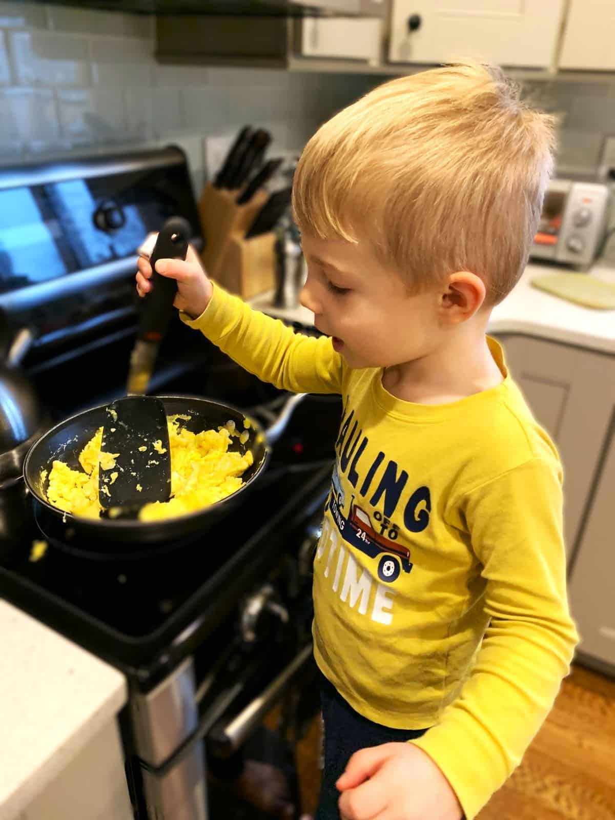 child making scrambled eggs